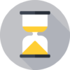 Hourglass with yellow sand, clear glass casing, on a grey background