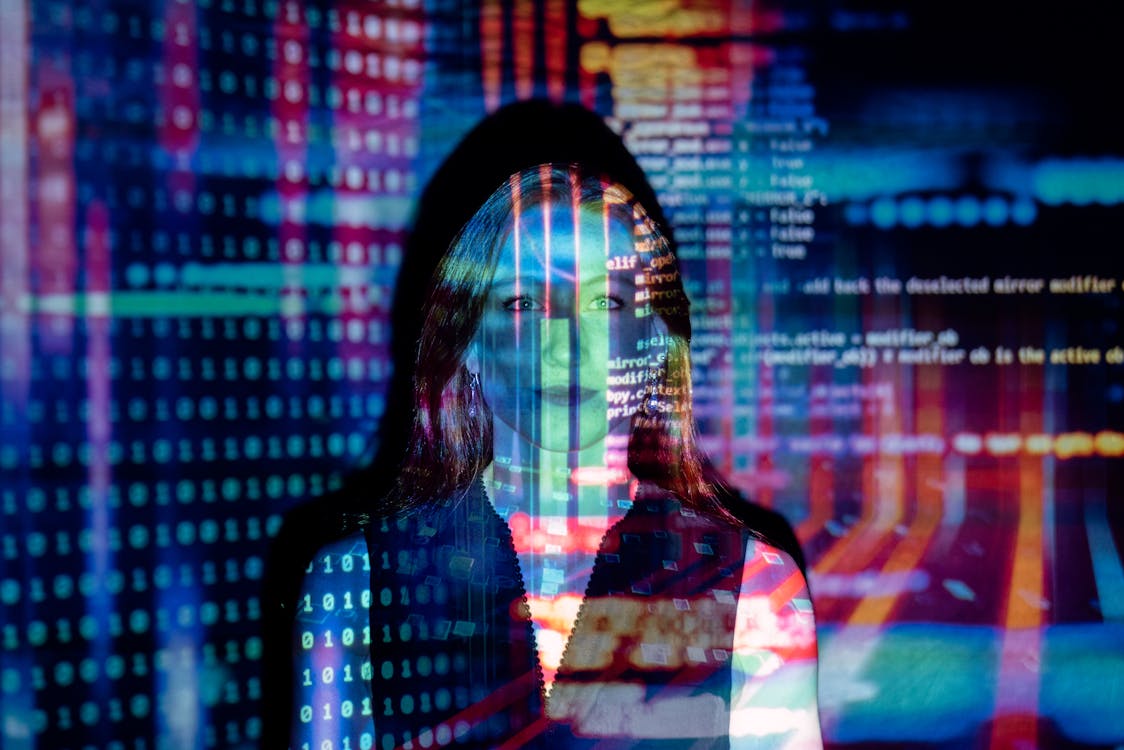 woman with digital code and data projections on skin and clothing in blue and red light