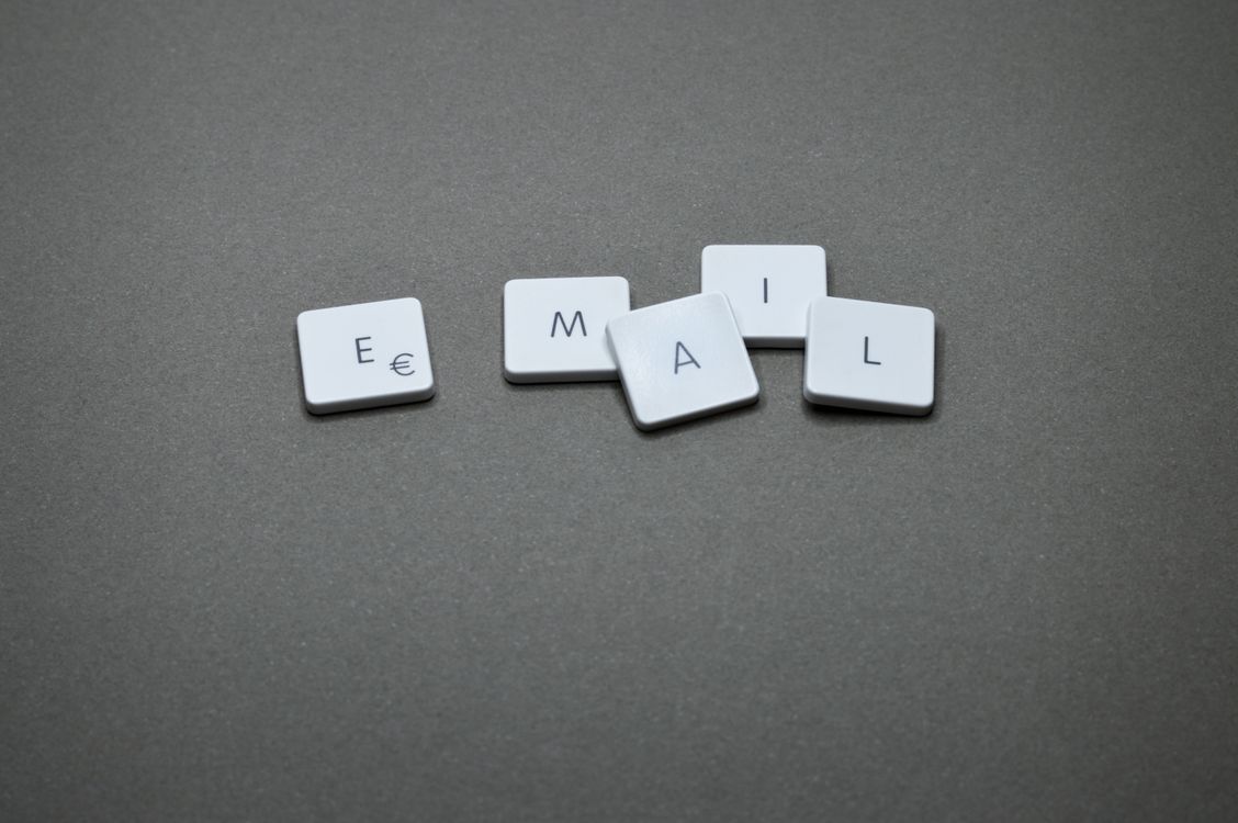 White plastic keyboard keys spelling 'EMAIL' on a grey surface
