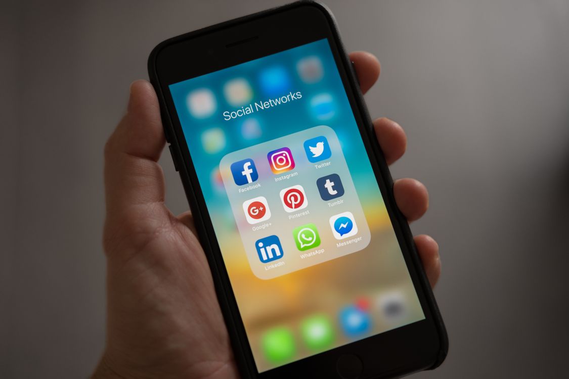smartphone with plastic case displaying colorful social media app icons on screen