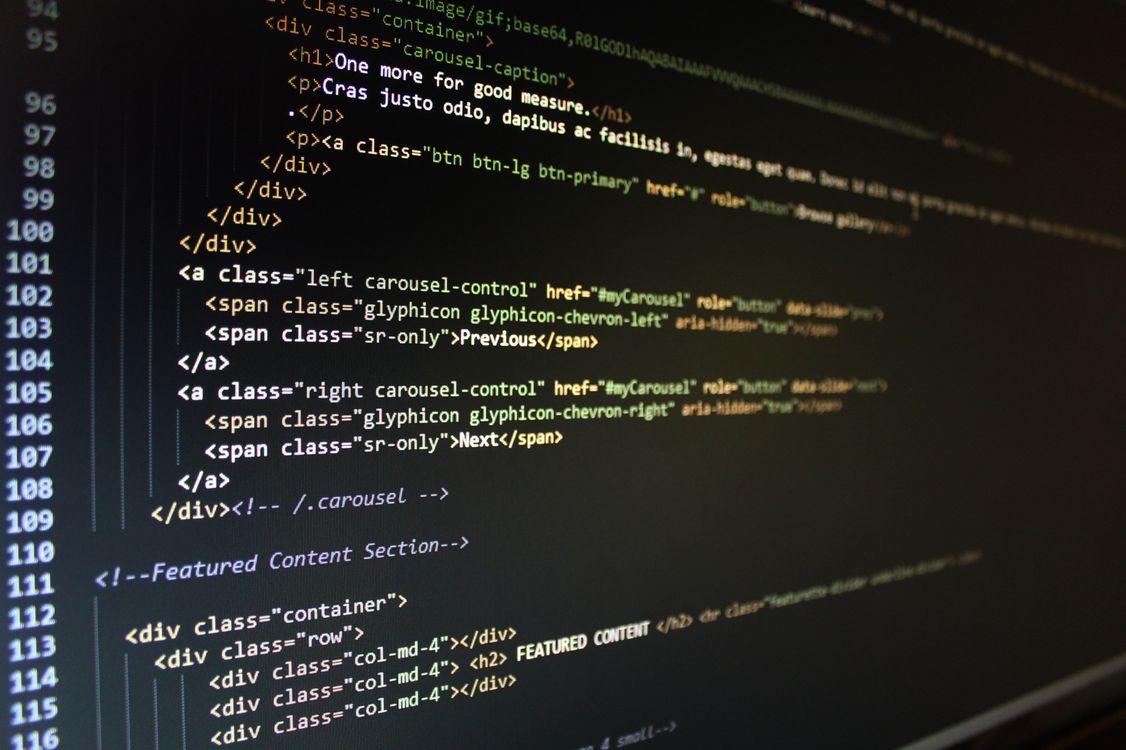 computer screen displaying HTML and CSS code with syntax highlighting on dark background