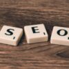 Scrabble tiles spelling SEO made of plastic on a wooden surface in brown color