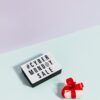 Lightbox with Cyber Monday Sale text and small gift box with red ribbon on pastel background