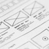 website wireframe sketches on white paper with black ink lines and text